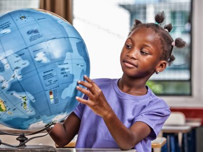 38280913 - african primary school girl studying world globe in the classroom.environment concept.